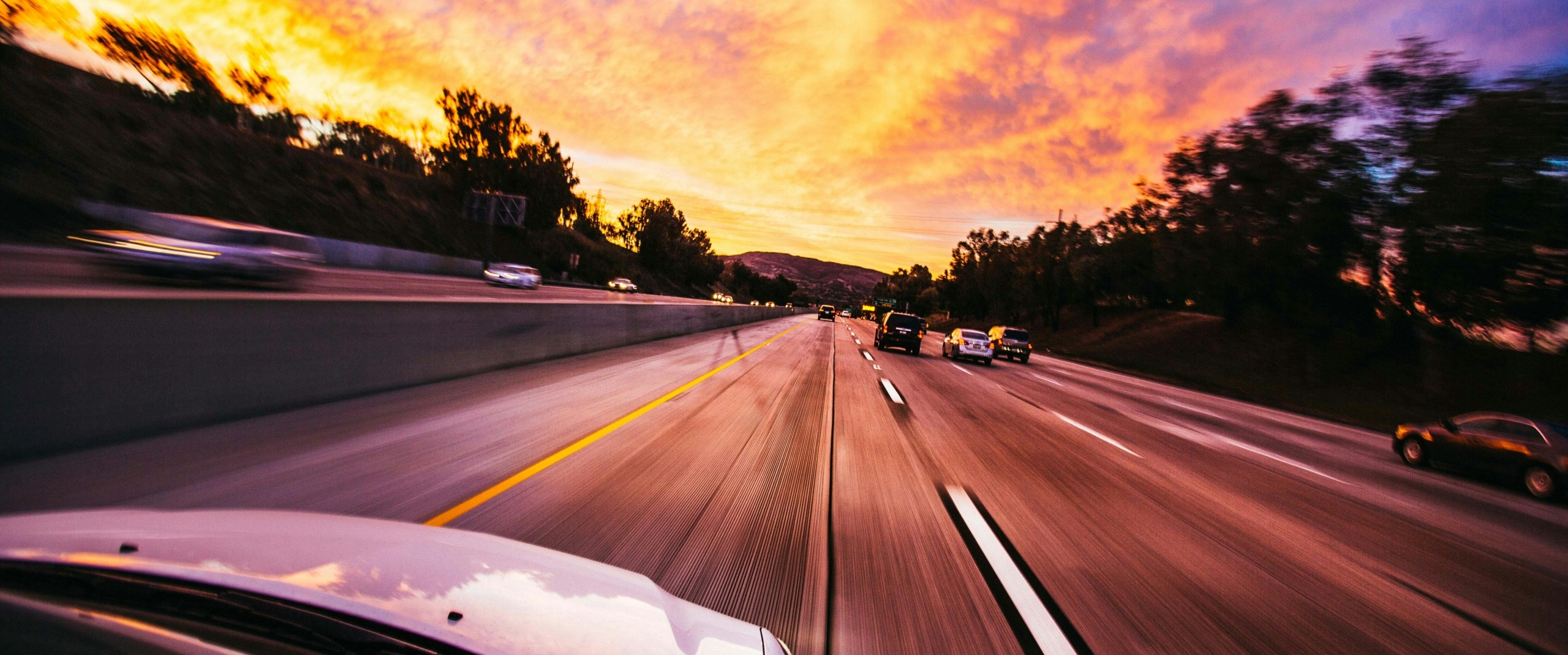 car-is-driving-down-highway-with-sunset-background